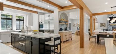 Spacious modern kitchen with wooden beams and large island.