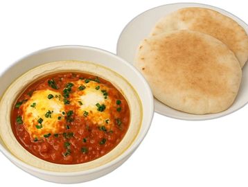 Rich tomato shakshuka with poached eggs over creamy hummus, served with warm, fluffy pocket pita.