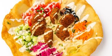 Crispy falafel bowl with tahini, fresh veggies, and pita — bursting with flavor and color.