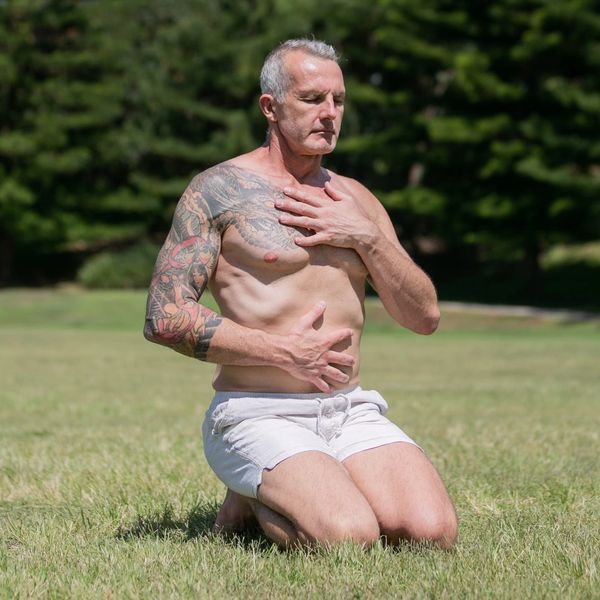 mark moon and practicing mindful breathing outdoors on grass.