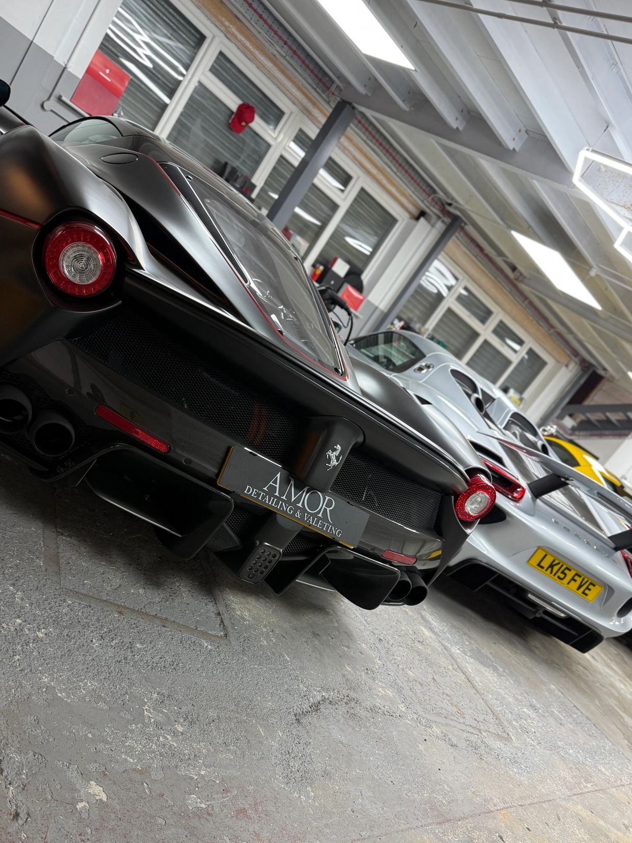 Luxury sports cars parked inside an indoor garage.
