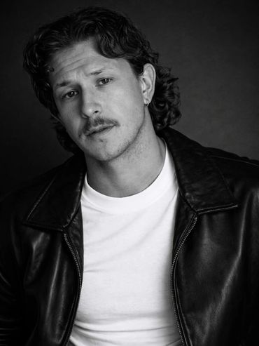 Black and white portrait of a man in leather jacket.
