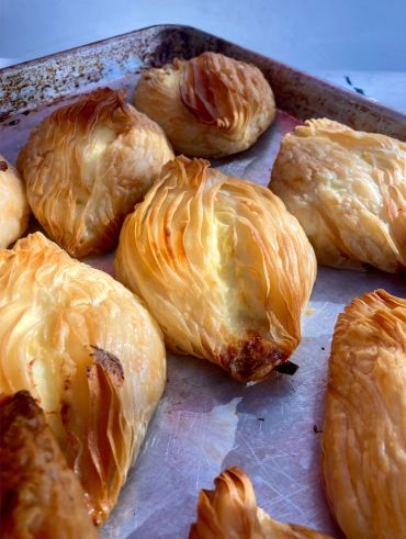 Freshly baked golden puff pastries on a baking tray.