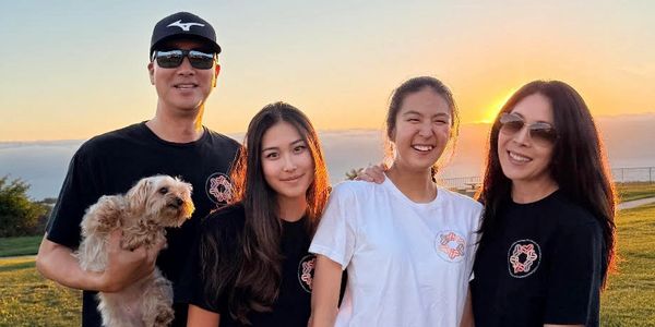 Happy family enjoying a sunset outdoors with their dog.