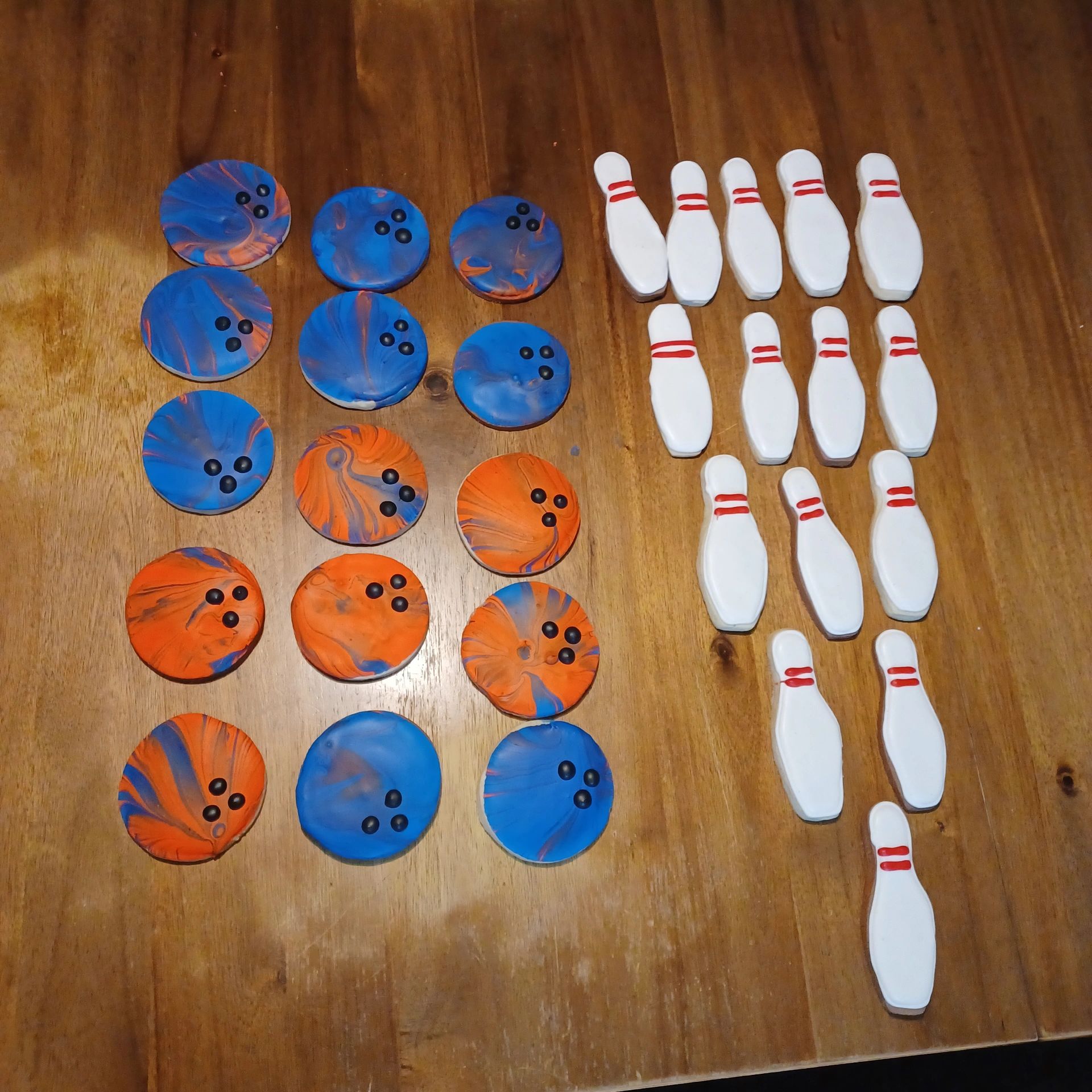 Handmade bowling pins and balls arranged on a wooden table.