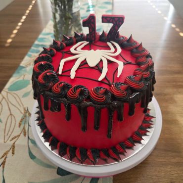 Red and black Spider-Man themed birthday cake with number 17 candles.