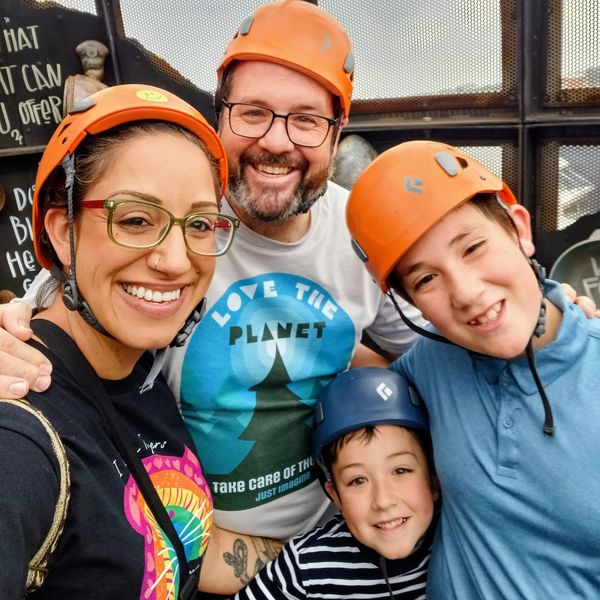 Smiling family wearing helmets ready for an outdoor adventure.