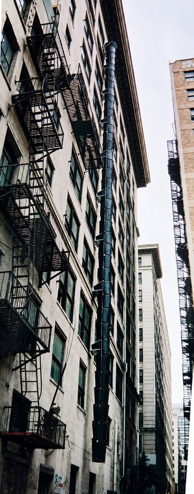 Buckets stacked vertically on a building's exterior for debris disposal.
