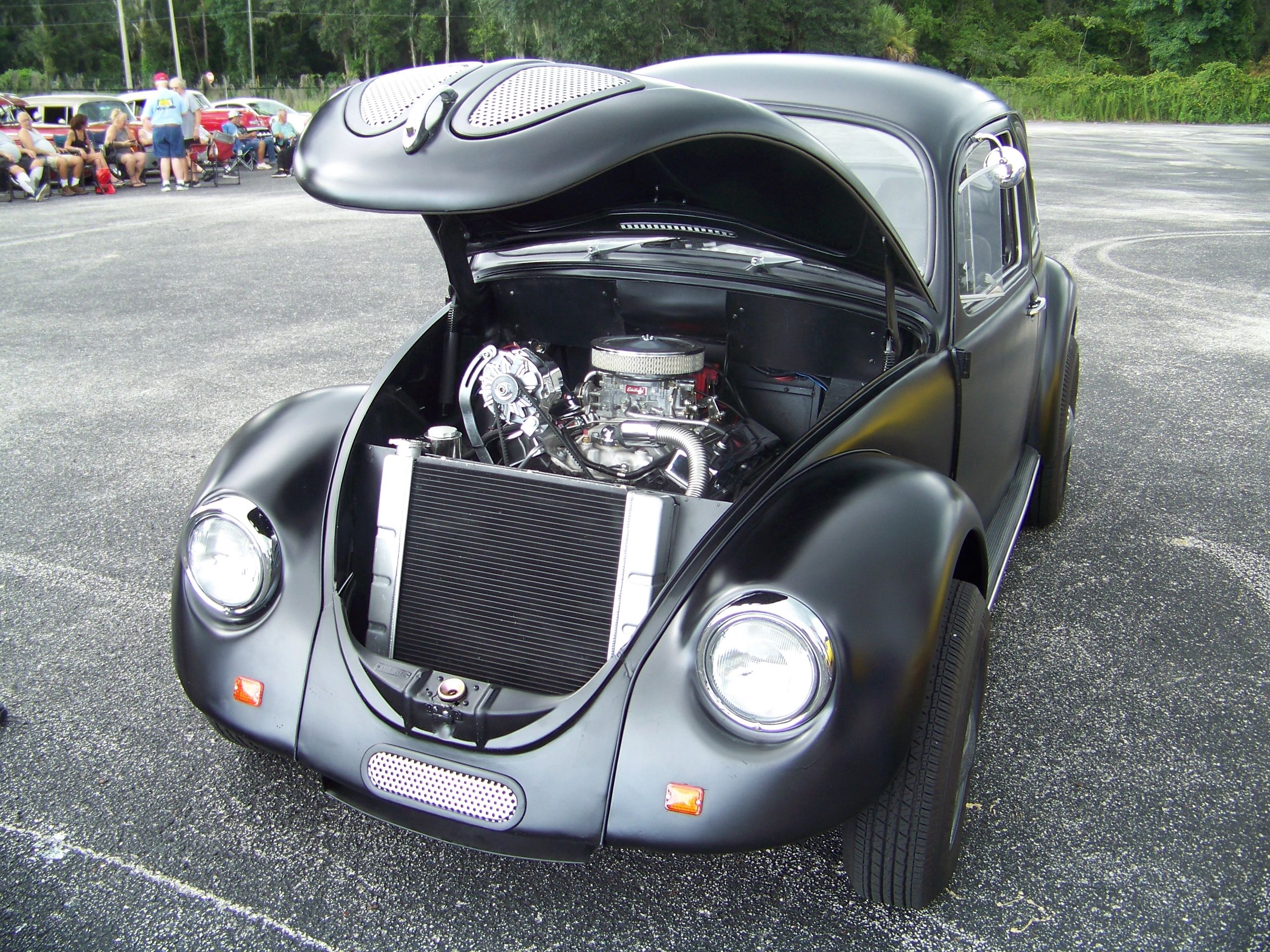 Classic black vintage car with open engine hood.