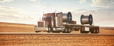 Flatbed truck with cable reels.