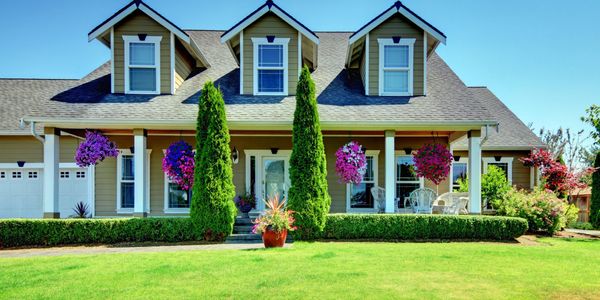 Sioux Falls Custom Siding On Beige Home With Pretty Pink Flowering Hanging Plants