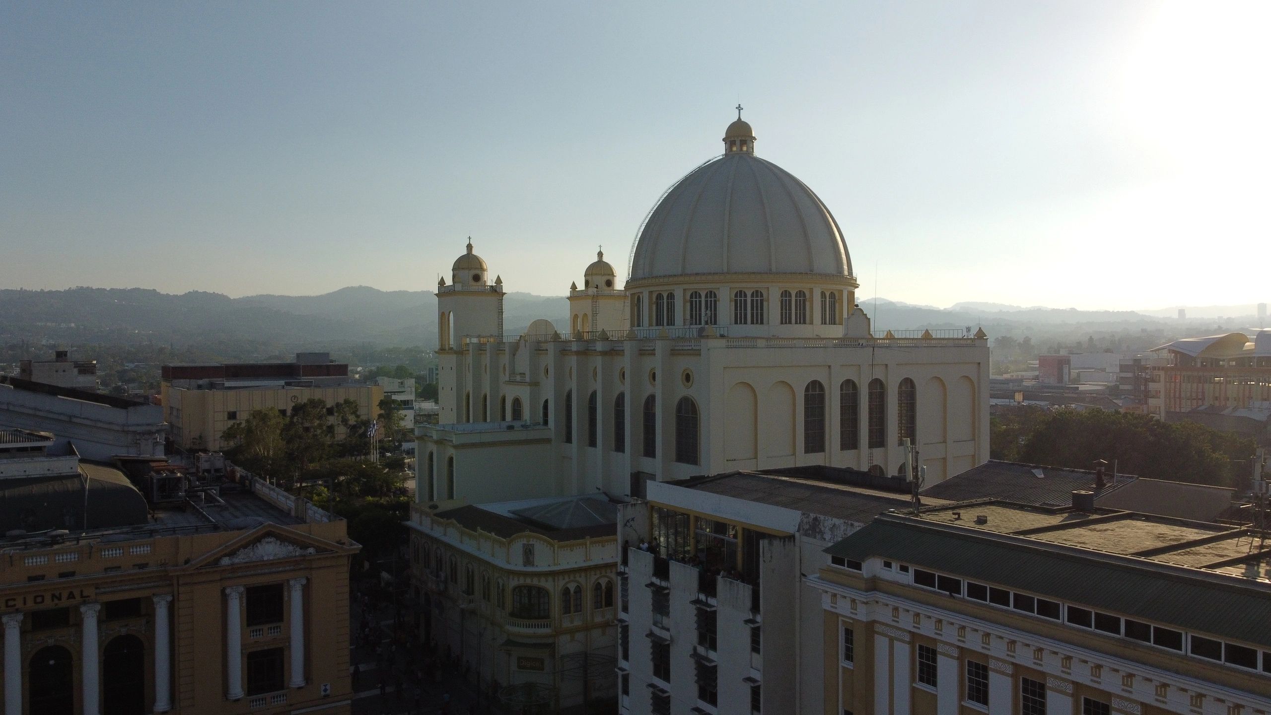 Gran catedral con cúpula y torres en ciudad al amanecer.