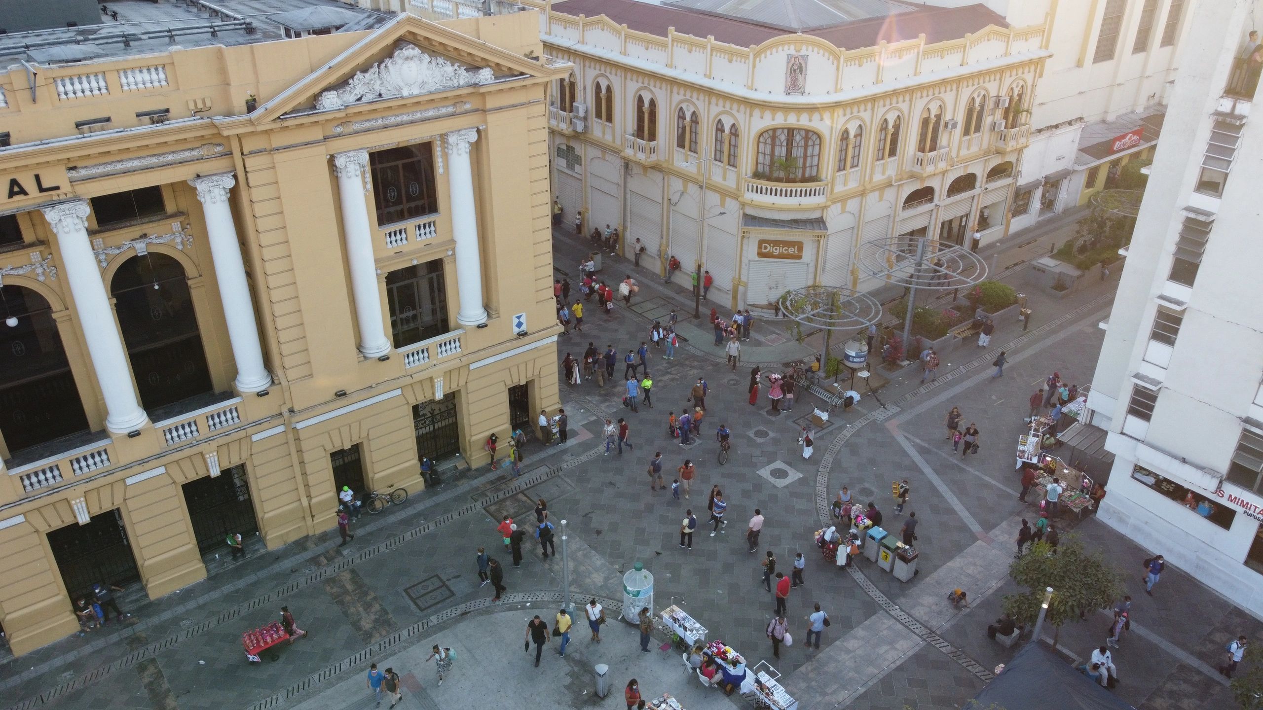 Plaza concurrida con edificios históricos y vendedores ambulantes.