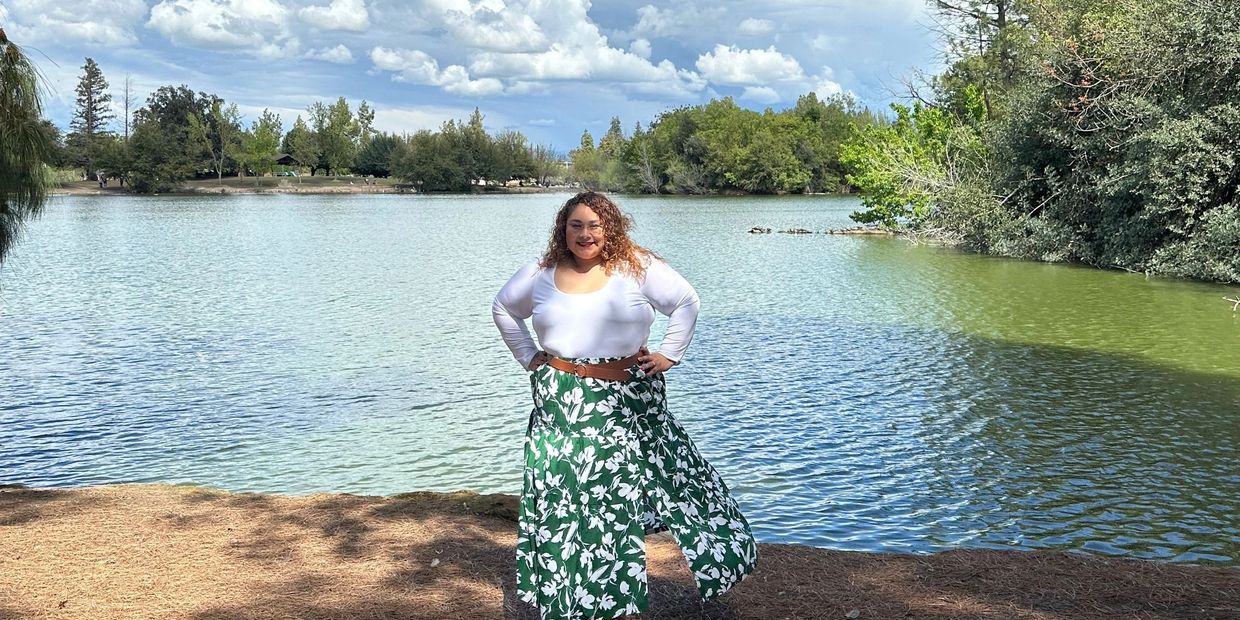 Maira standing in front of a lake. 