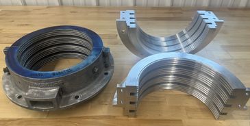 Metal coil springs and curved metal components on a wooden surface.