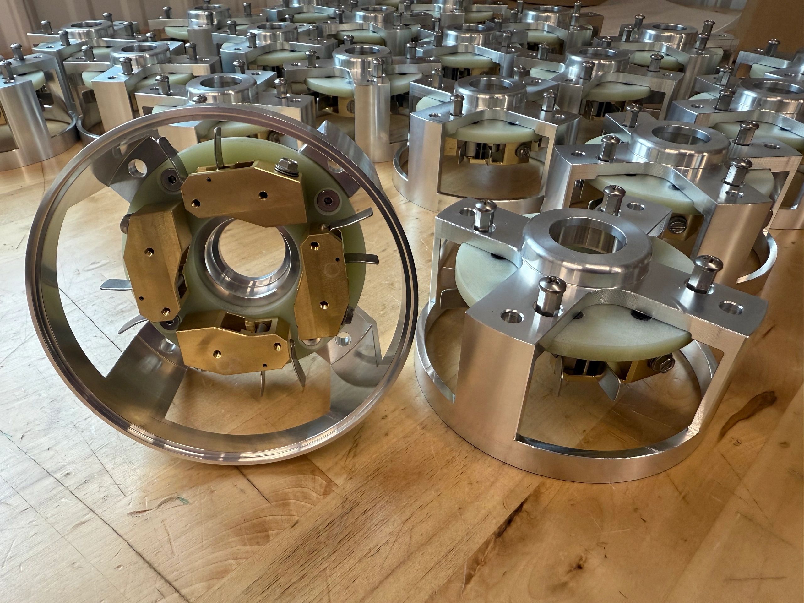 Metal mechanical components arranged on a wooden surface.