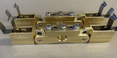 Close-up of brass mechanical parts with screws and levers.