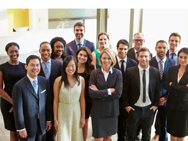 Lots of male & female office workers grouped together looking at the camera