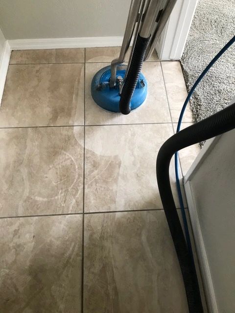 A floor with dirty tiles being cleaned