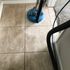 A floor with dirty tiles being cleaned