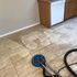 A floor with dirty tiles being cleaned