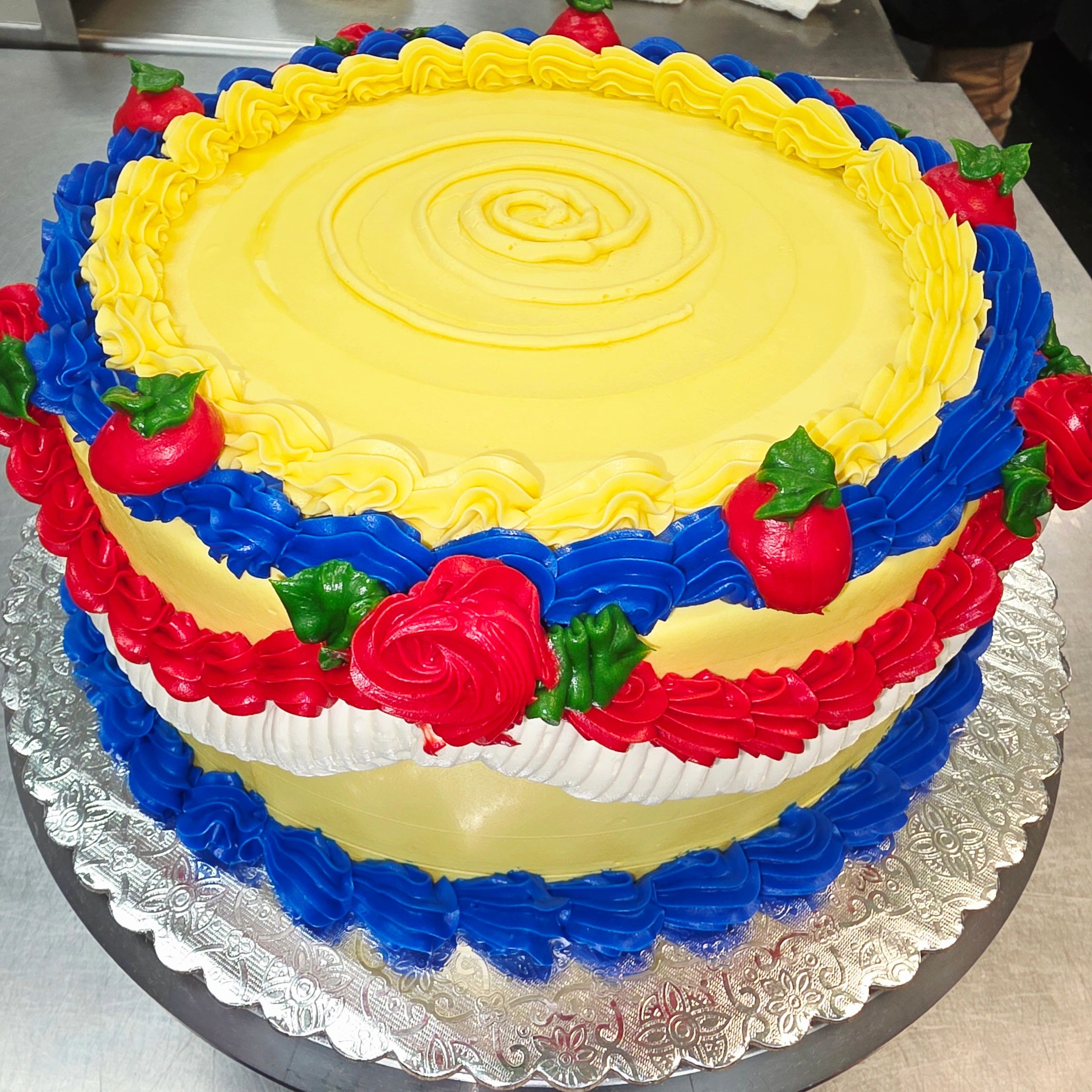 Colorful decorated cake with yellow, blue, red, and green frosting.