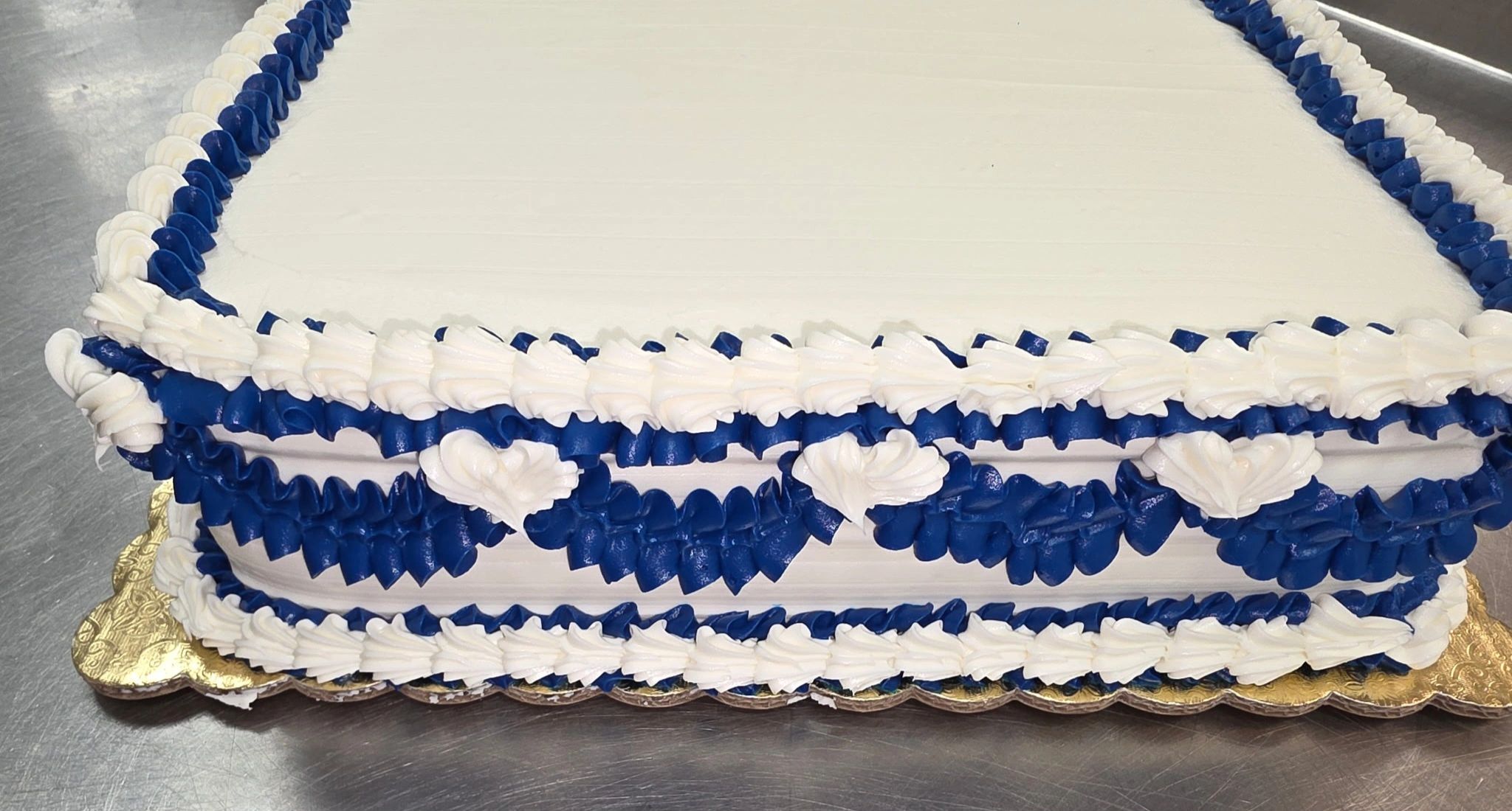 Rectangular cake with white and blue frosting decorations.