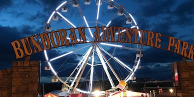 Illuminated Ferris wheel at Bundoran Adventure Park during twilight.