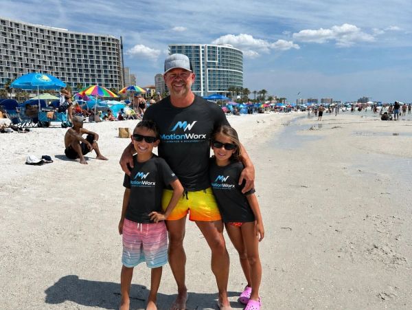 Father with two kids on a sunny beach.
