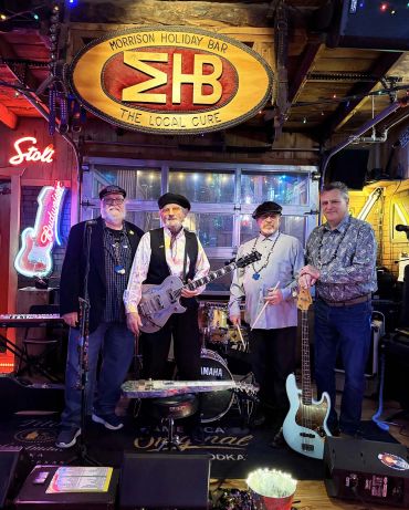 Four musicians posing with instruments at Morrison Holiday Bar.