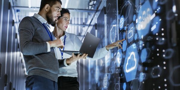 Two professionals analyzing data on a futuristic digital interface.