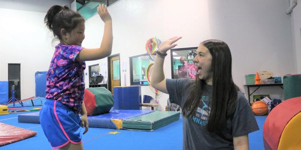 Coach instructor giving gymnast a high five