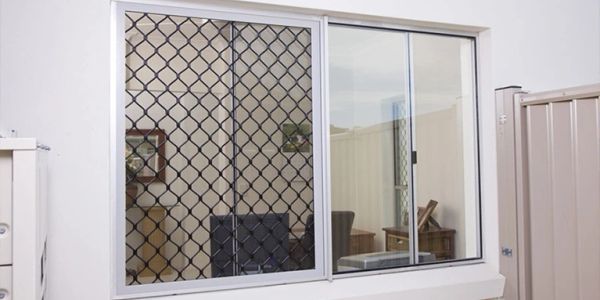 Window with a security mesh screen and sliding glass panes.