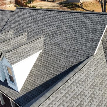 Close-up of a newly shingled roof on a house with multiple gables.