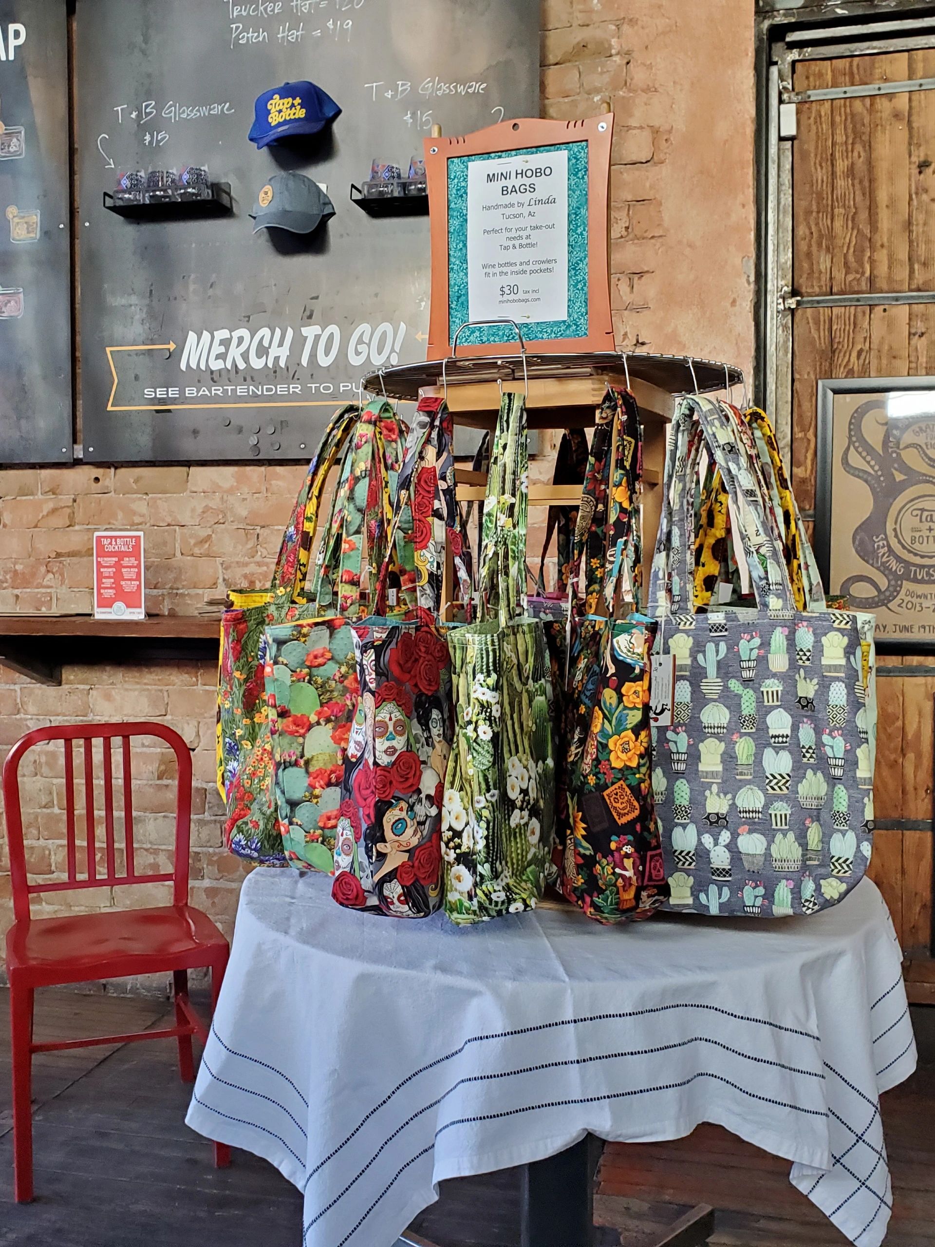 Colorful mini hobo bags displayed on a table in a rustic cafe setting.