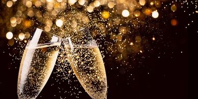 Two champagne glasses clinking with sparkling bubbles.