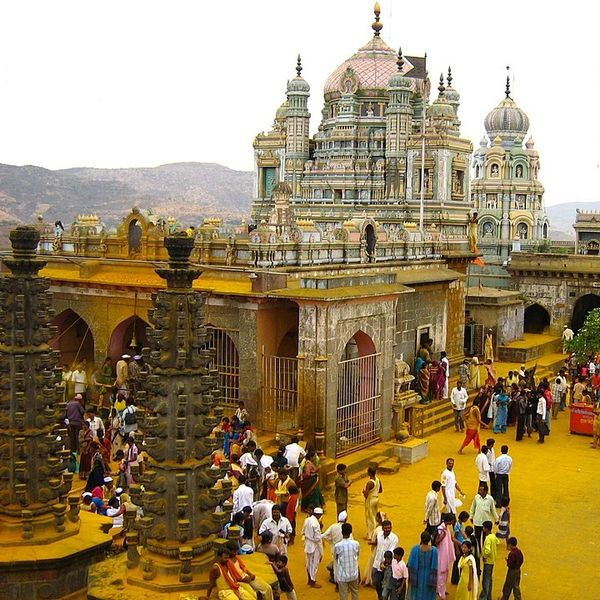 Crowded temple complex with intricate architecture and visitors in colorful attire.