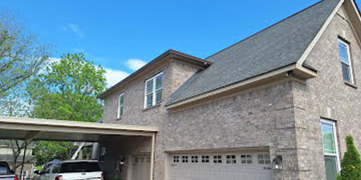Modern two-story brick house with a carport and a white pickup truck.