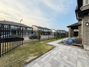 A suburban backyard with a tiled patio and view of nearby houses.