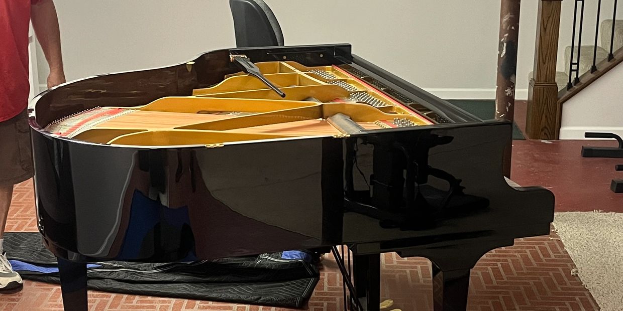 Grand Piano bring prepped for moving with moving blankets.