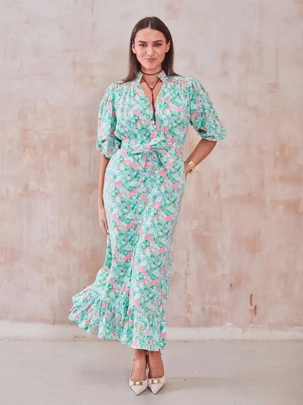 Woman in a floral maxi dress with puff sleeves and ruffled hem.