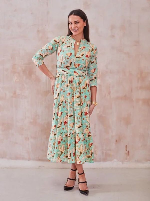 Woman wearing a floral patterned midi dress and black heels.