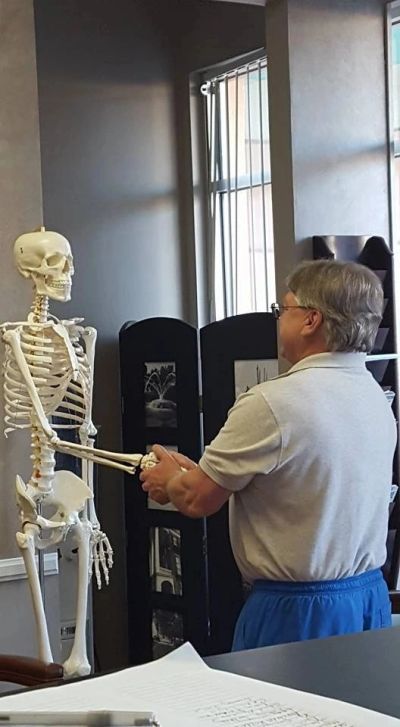 Man shaking hands with a skeleton model.