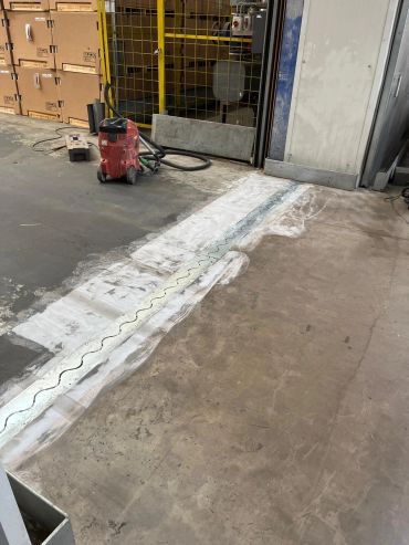 Bodensanierung in einer Lagerhalle mit Reinigungsgeräten.