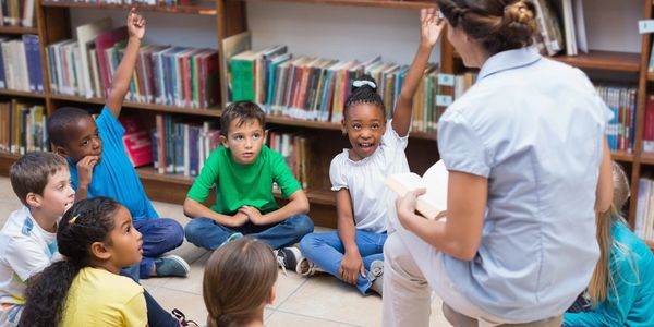 woman reading a book to kids