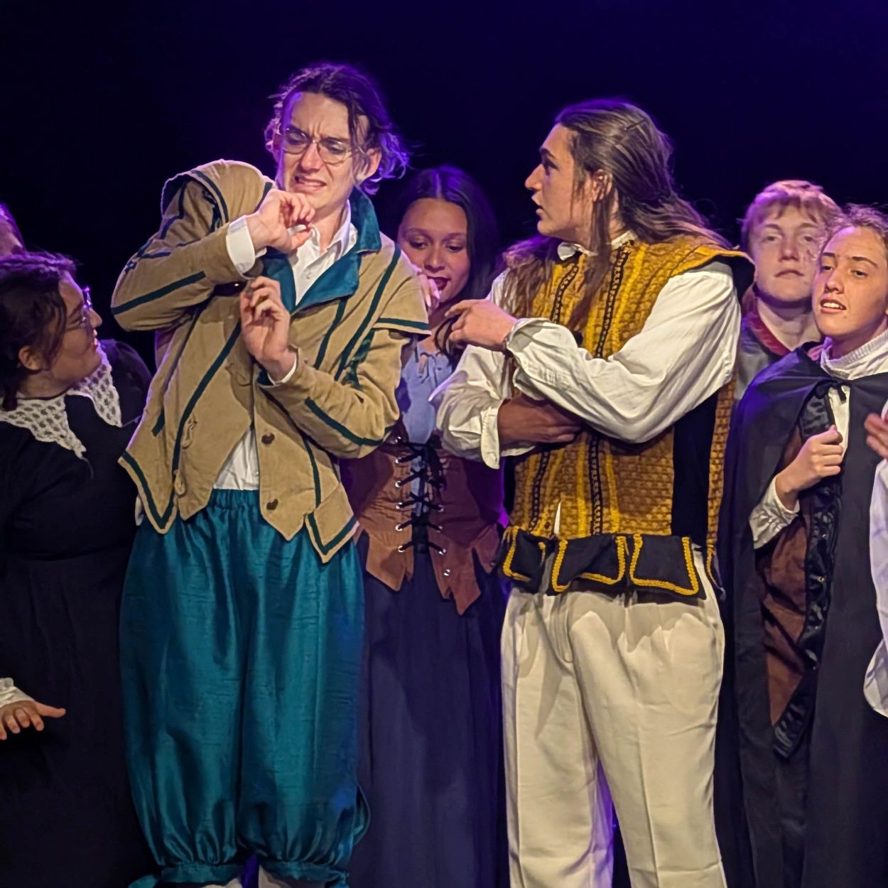 Actors in Renaissance-style costumes during a dramatic scene on stage.