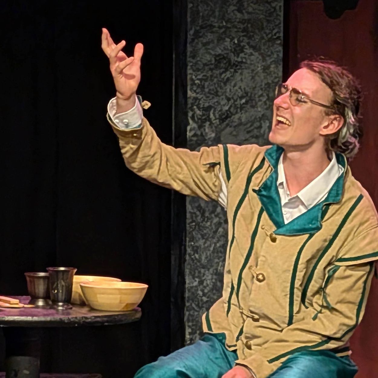 Actor passionately performing on stage in vintage attire.