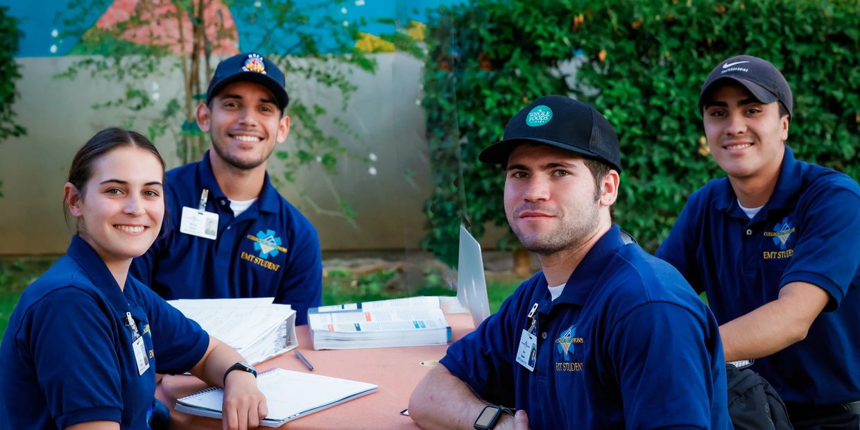 Three men and a woman sitting around a table and smiling