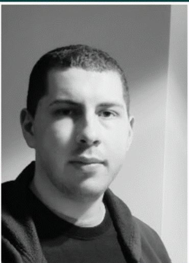 Black and white portrait of a man with short hair looking at the camera.