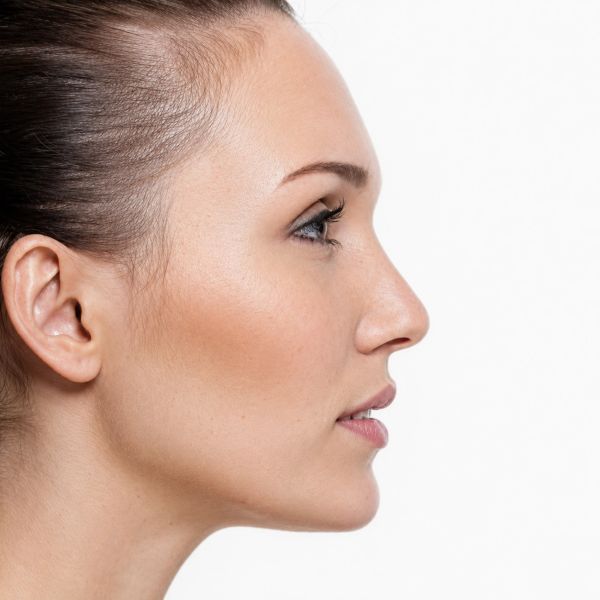 Perfil de mujer con piel limpia sobre fondo blanco.